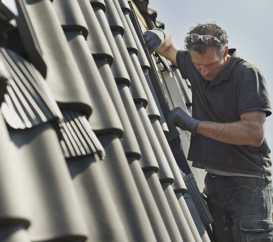 Montaż dachówki na&nbsp;dachu podczas prac dekarskich